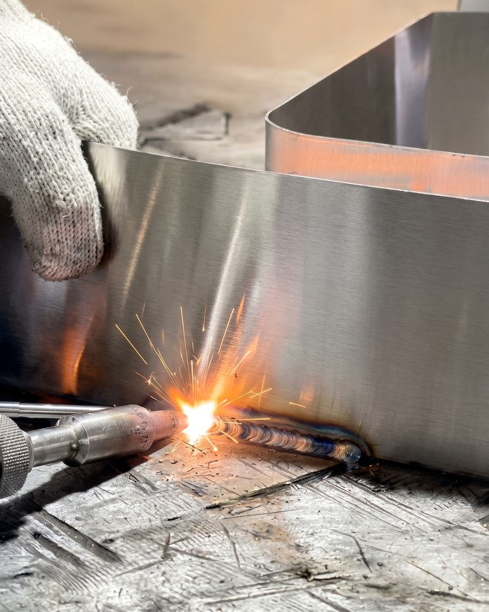 Welding tool joining a metal sign component