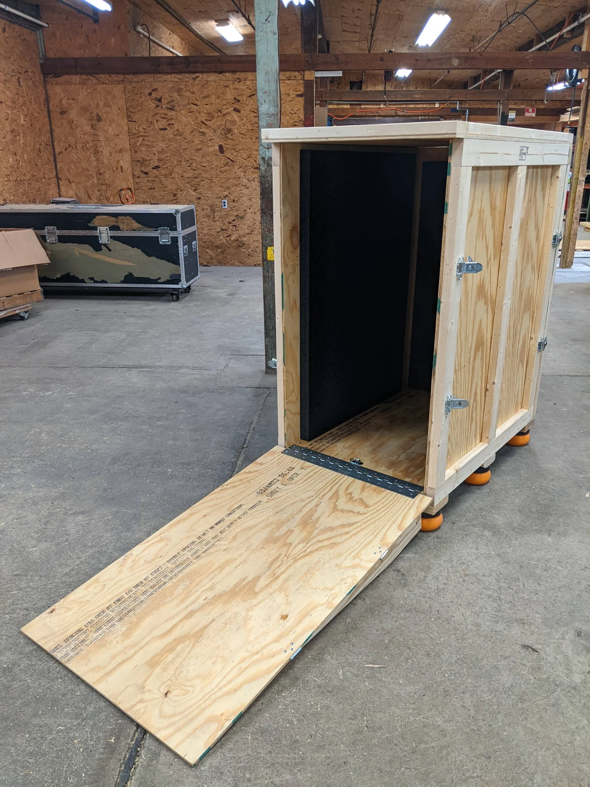 Illustrative reference photo of an open plywood shipping crate with protective foam lining