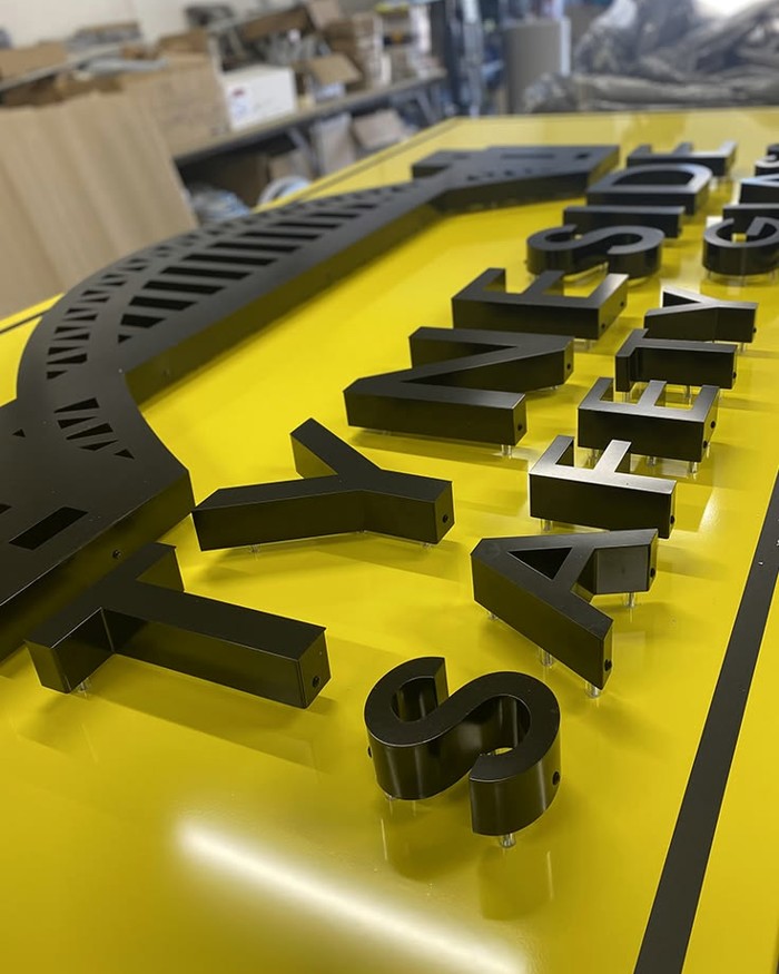 Letter components arranged on a yellow work surface