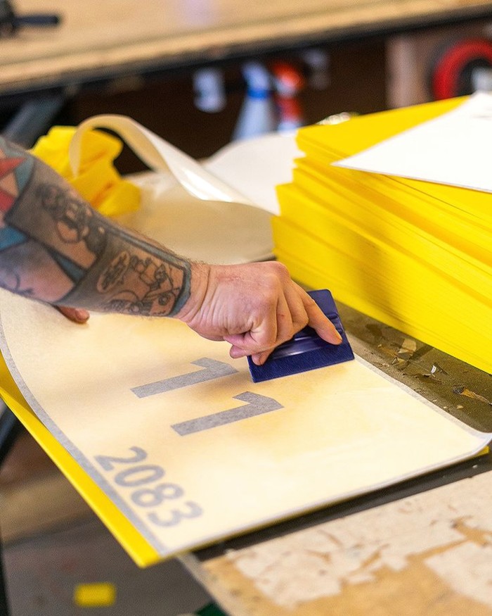 Worker applying a graphic to a sign panel